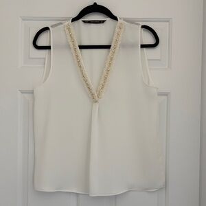 Elegant White Sleeveless Top with Textured Trim
